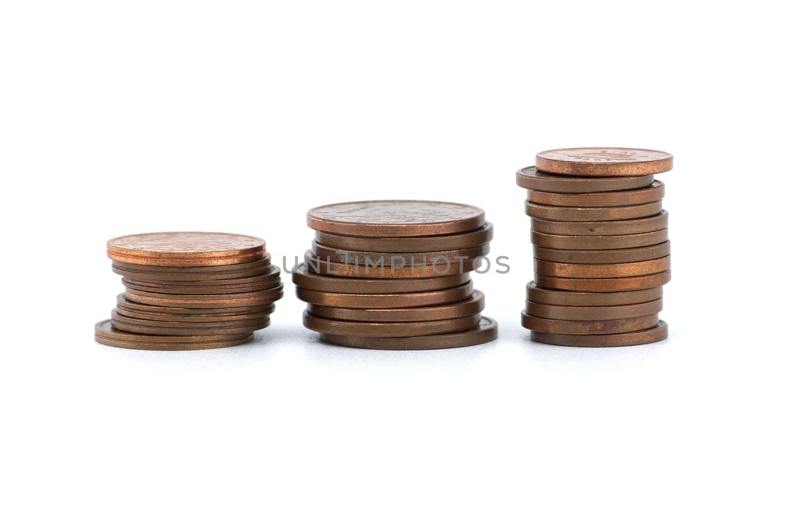 Stacks of coins ordered by size from largest to smallest and arranged from left to right isolated on white background