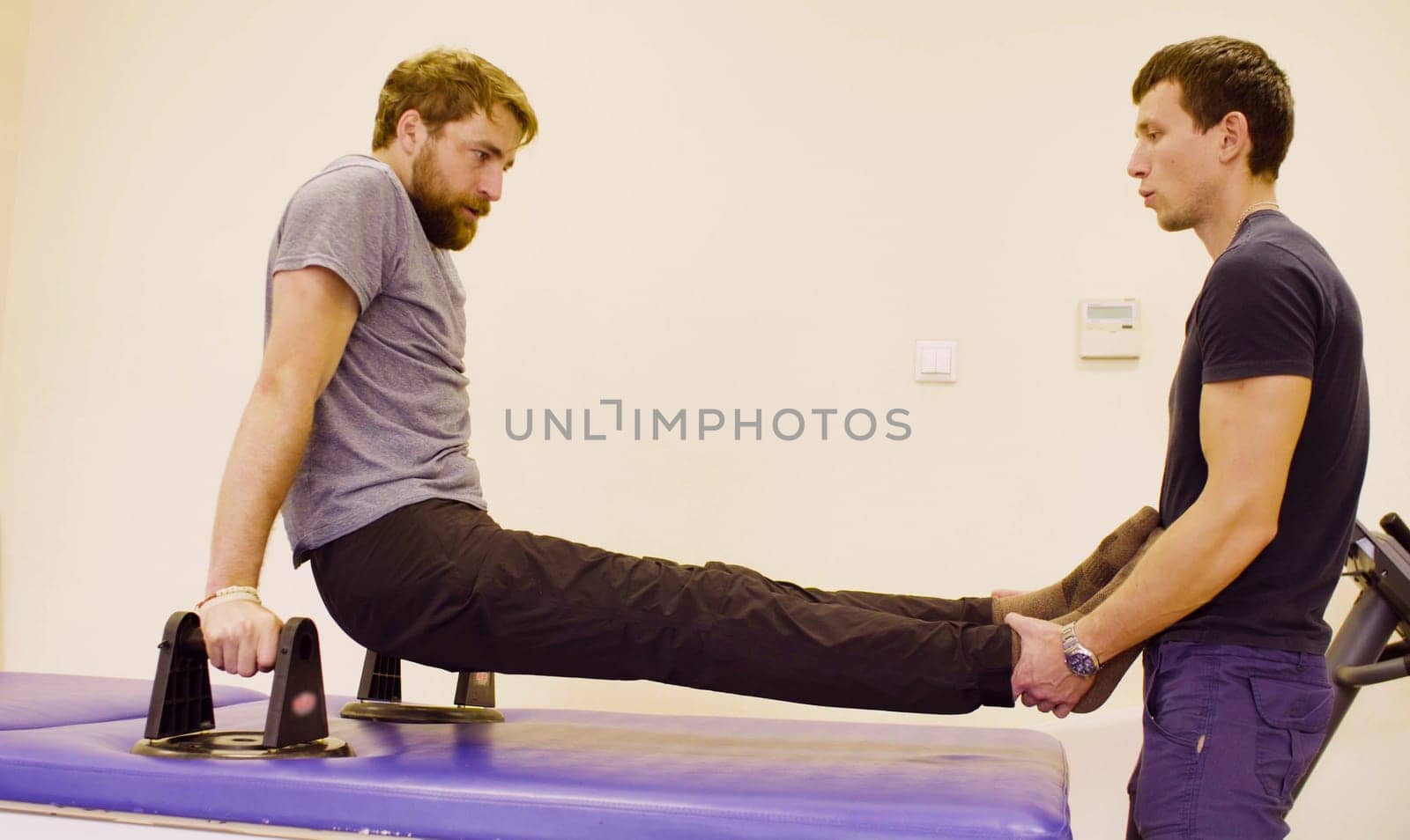 Doctor physiotherapist helping the patient to do the exercise by Chudakov