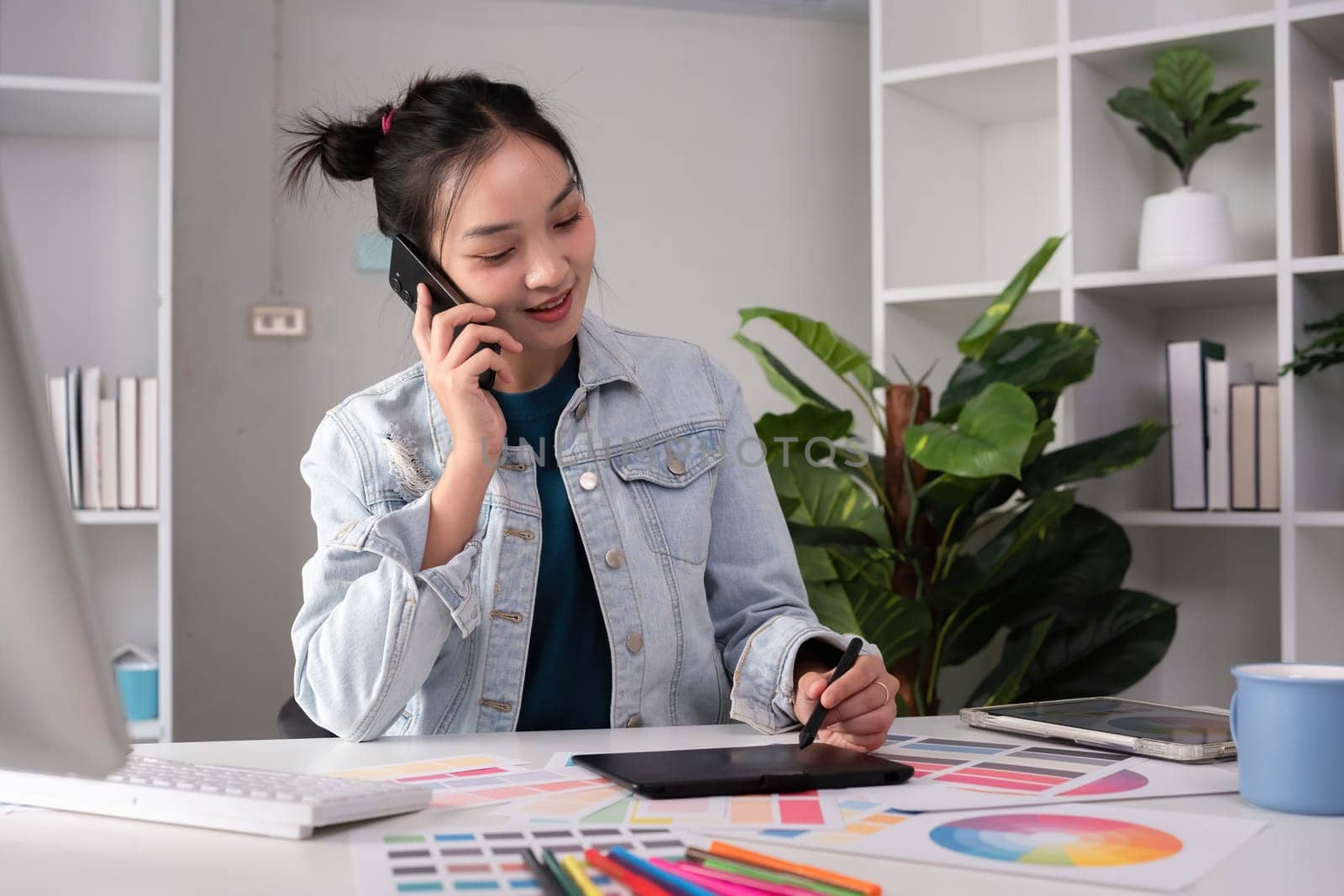 designer working in graphic design talks in a meeting over tones while choosing colors for work by wichayada