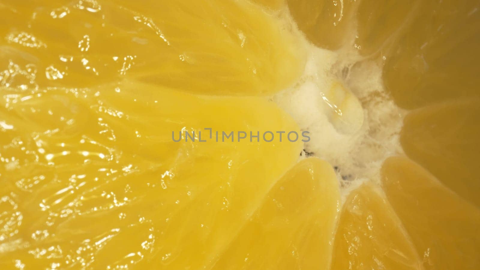 The macro photography of a sliced orange with vibrant orange color and visible in the juicy flesh of the citrus fruit. The flesh of the orange appears plump, hinting at its juiciness. Comestible.