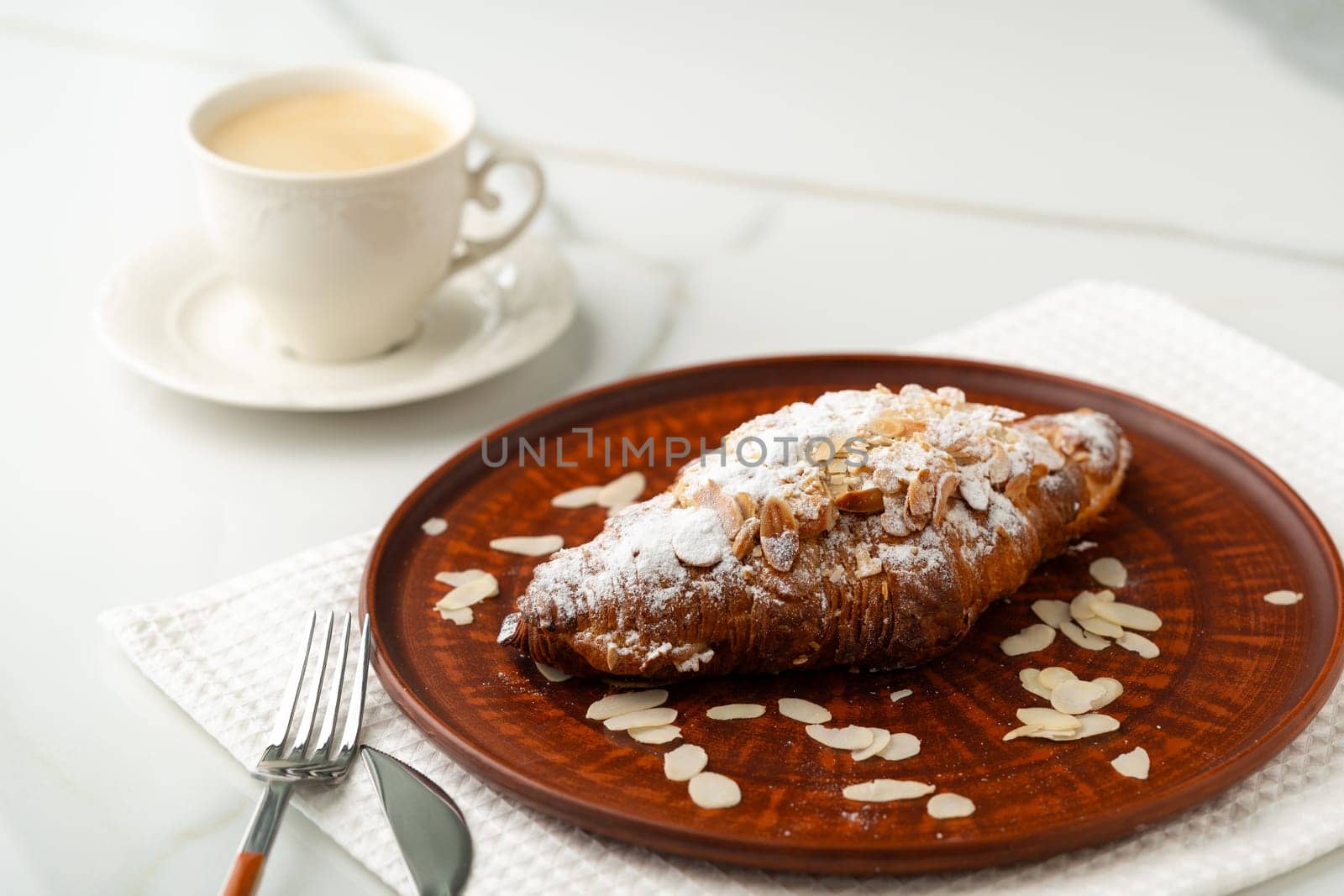 Almond Croissant on clay plate close up by Fabrikasimf