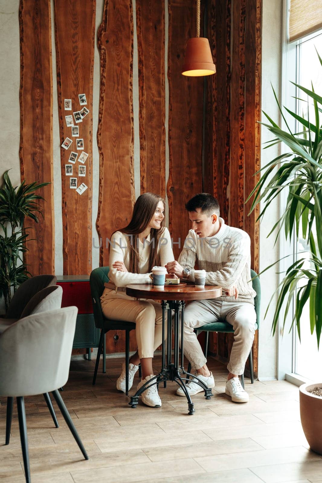 Young Couple Enjoying a Coffee Date at a Cozy Cafe During Afternoon Hours by Fabrikasimf