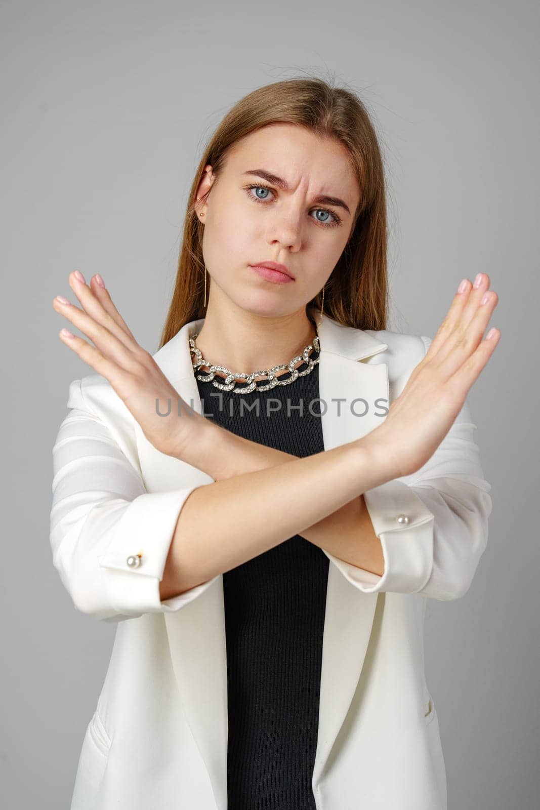 Woman in White Jacket Holding Hands Crossed in studio