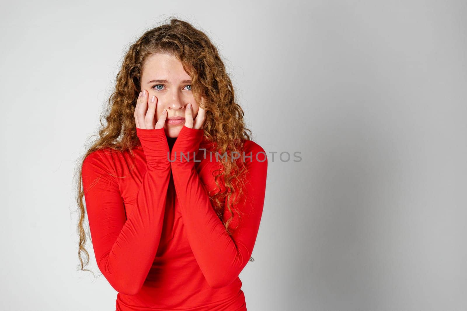 Young Woman With Curly Hair Expressing Concern by Fabrikasimf