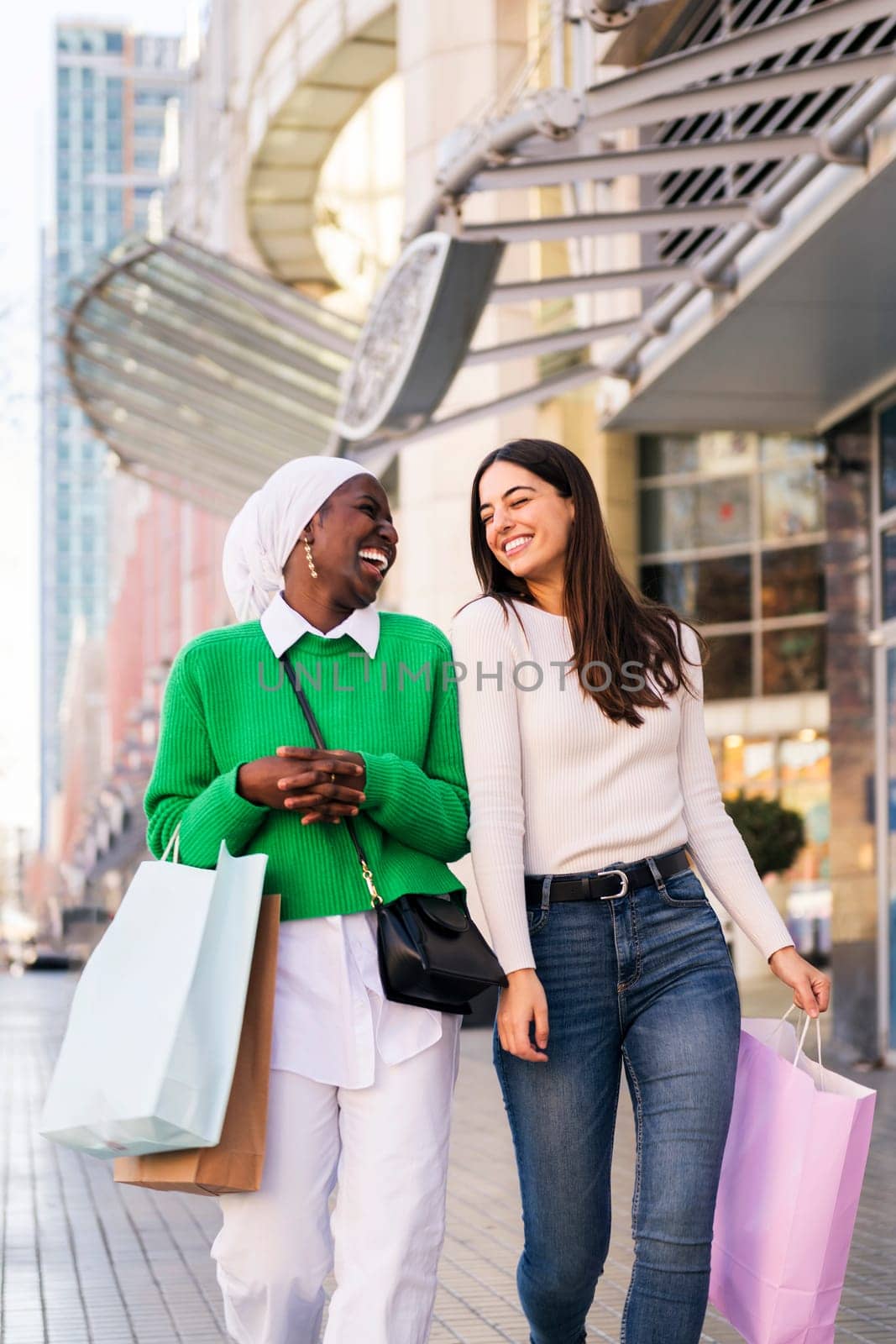 couple of female friends walking in shopping area by raulmelldo