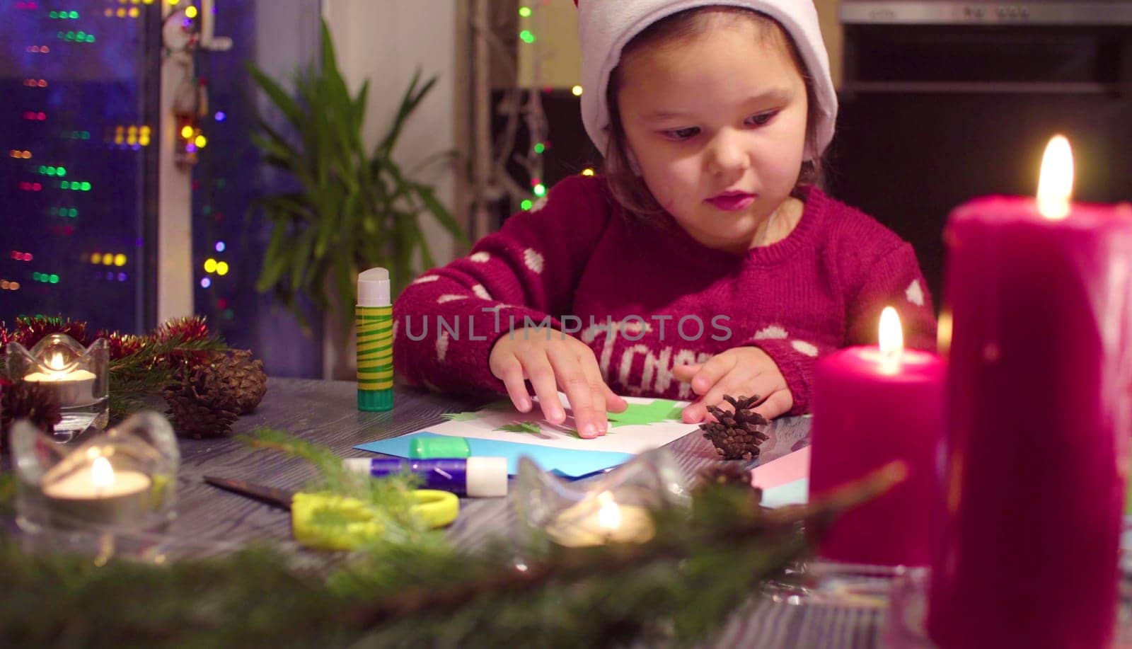 Little girl glues the New Year card by Chudakov