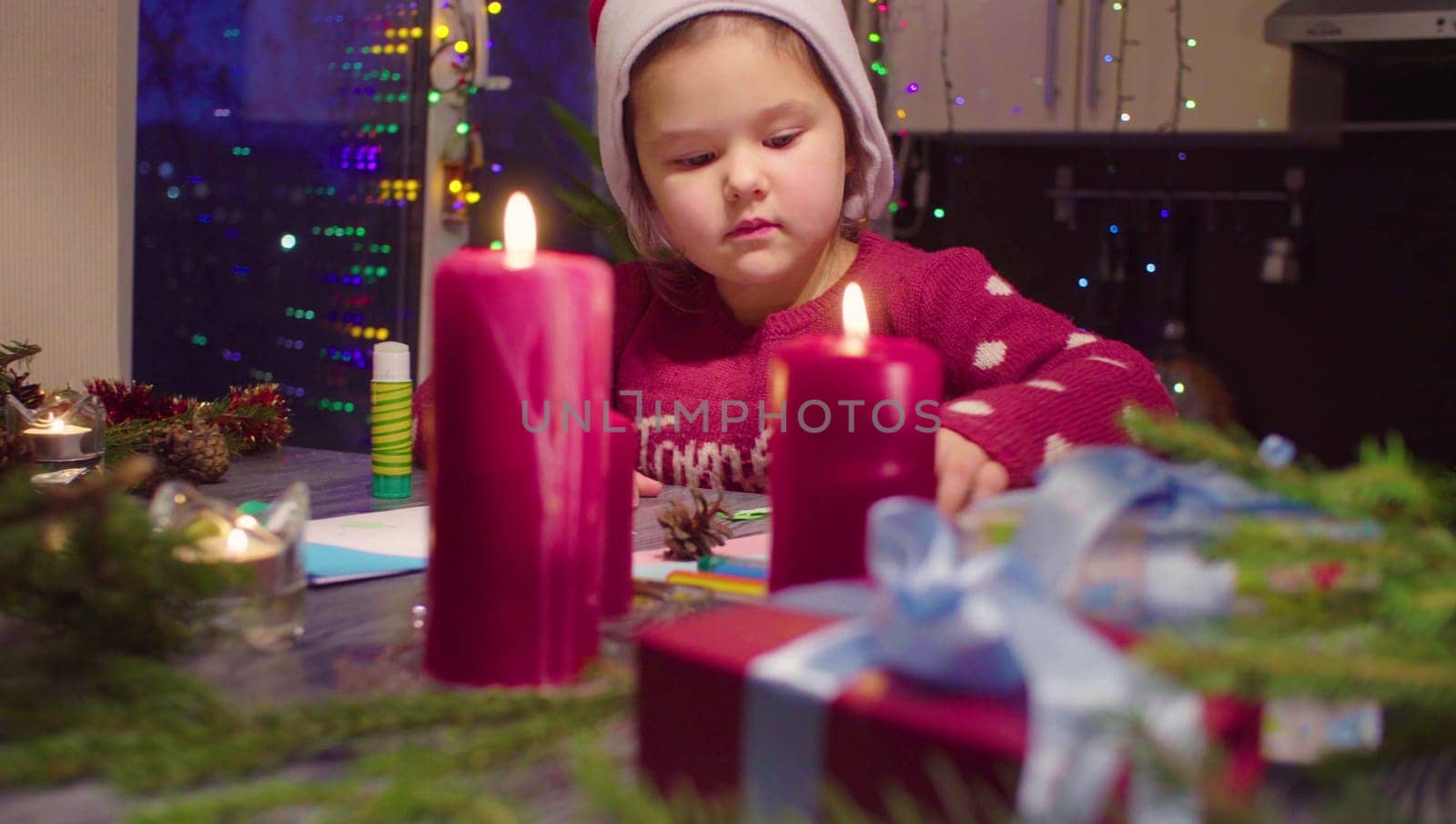 Little girl glues the New Year card by Chudakov
