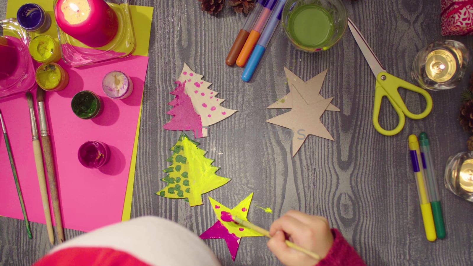 Little girl's hands painting a cardboard stars by Chudakov