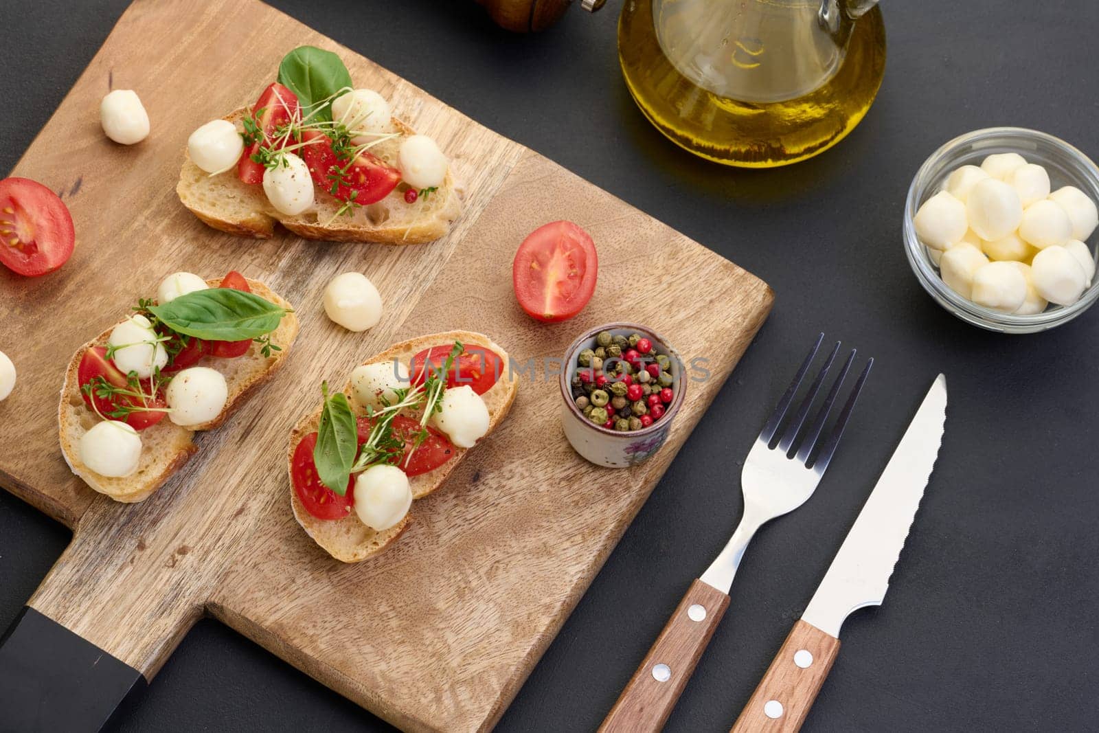 Round mozzarella, cherry tomatoes and microgreens on a piece of white bread, a healthy sandwich
