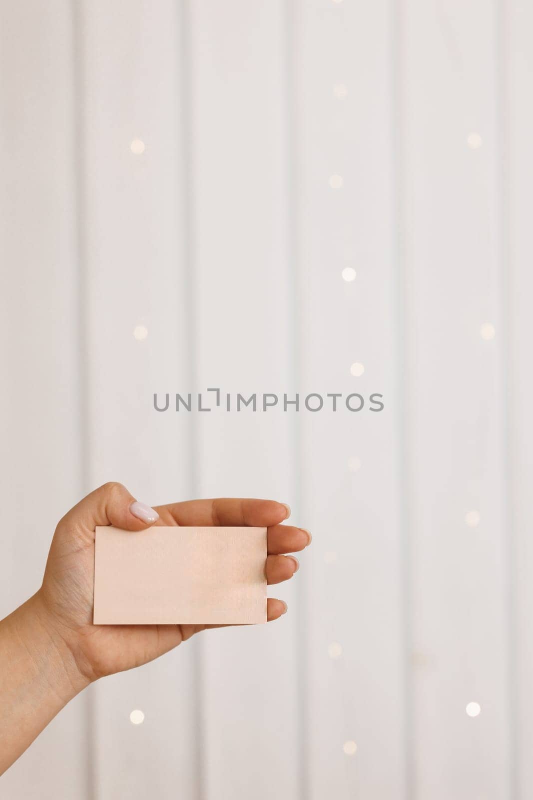 Female hands, empty menu, discount card, business card on beauty background with copy space. Mockup Design Template. Woman hand holding empty business card, credit card or blank paper.