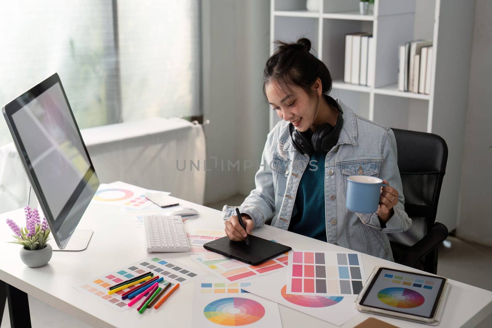 UX designer. Work on creative applications. Man with a palette in his hands. Designer applies the primary colors to the monitors. Development of a training application. Designer is a freelancer.