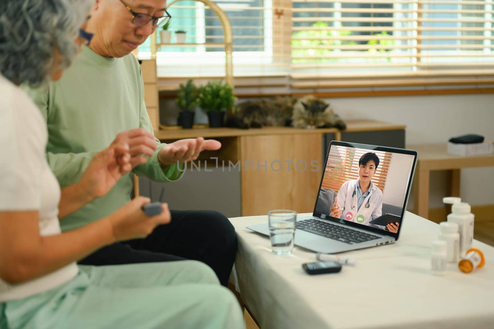 Middle aged couple having online consultation with doctor on laptop. Telemedicine concept.