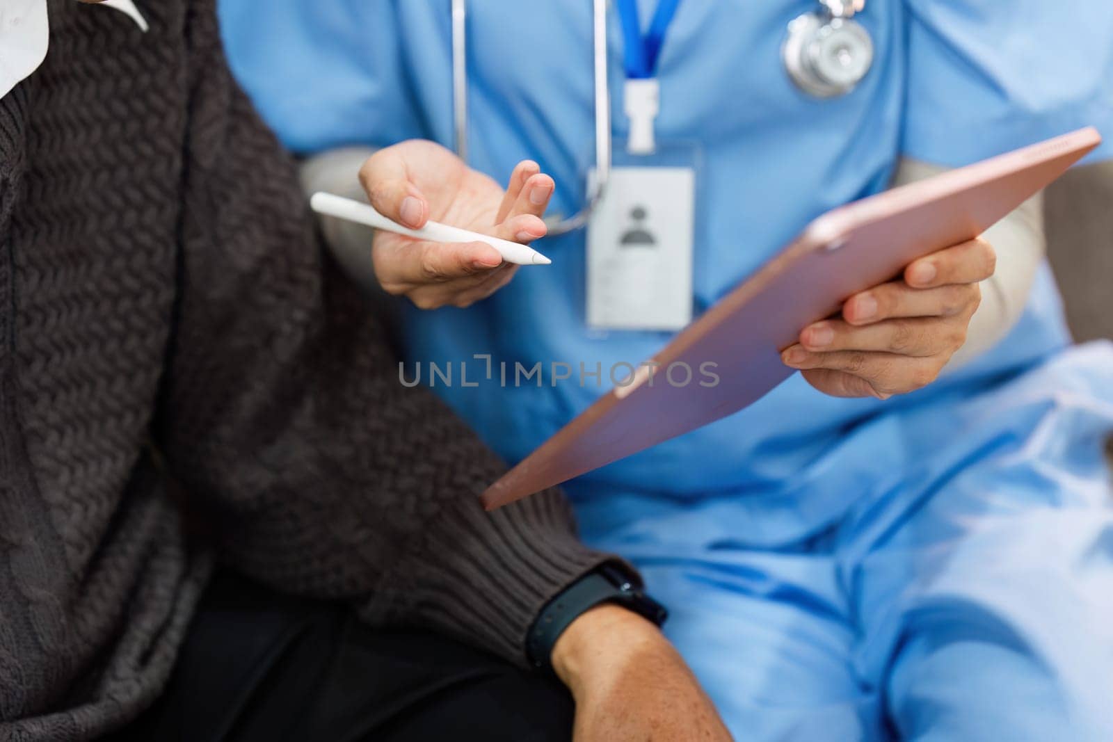 A nurse is talking to an older man about his health. The nurse is holding a clipboard and a pen