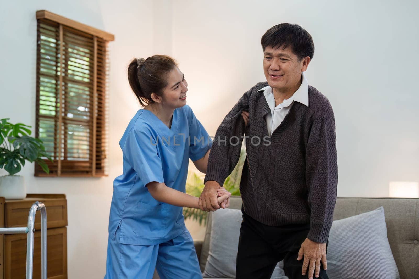caregiver or nurse help support elderly are standing up without walker at home by itchaznong