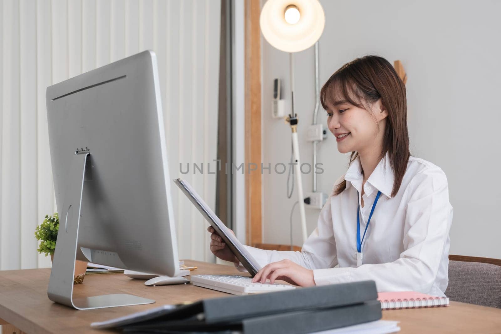 Cheerful business lady working on computer in office, Asian happy beautiful businesswoman in formal suit work in workplace. Attractive female employee office worker smile..