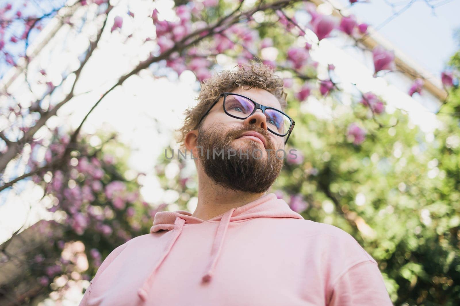 Springtime concept. Bearded man on background bloom of magnolia. Spring beauty season. Botany and nature. Happy spring concept. Hipster guy enjoy blossom aroma. by Satura86