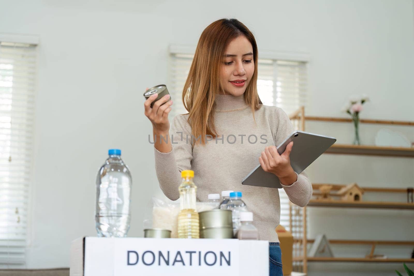 charity, donation and volunteering concept. Volunteer prepare foodstuff box containing food to donate to people poor, disaster victim at home by itchaznong