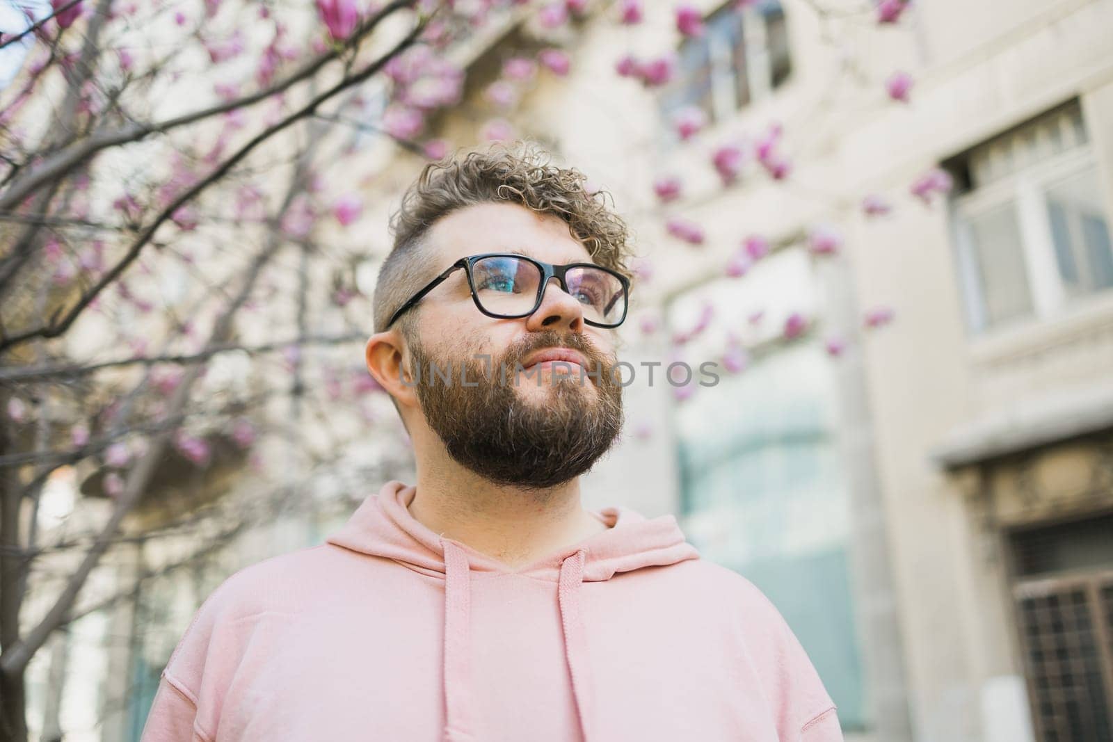 Springtime concept. Bearded man on background bloom of magnolia. Spring beauty season. Botany and nature. Happy spring concept. Hipster guy enjoy blossom aroma. by Satura86
