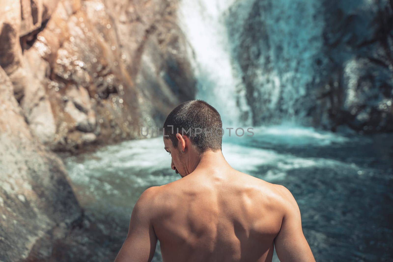 Summer background back shot of a male in front of crystal clear waterfalls. by PaulCarr