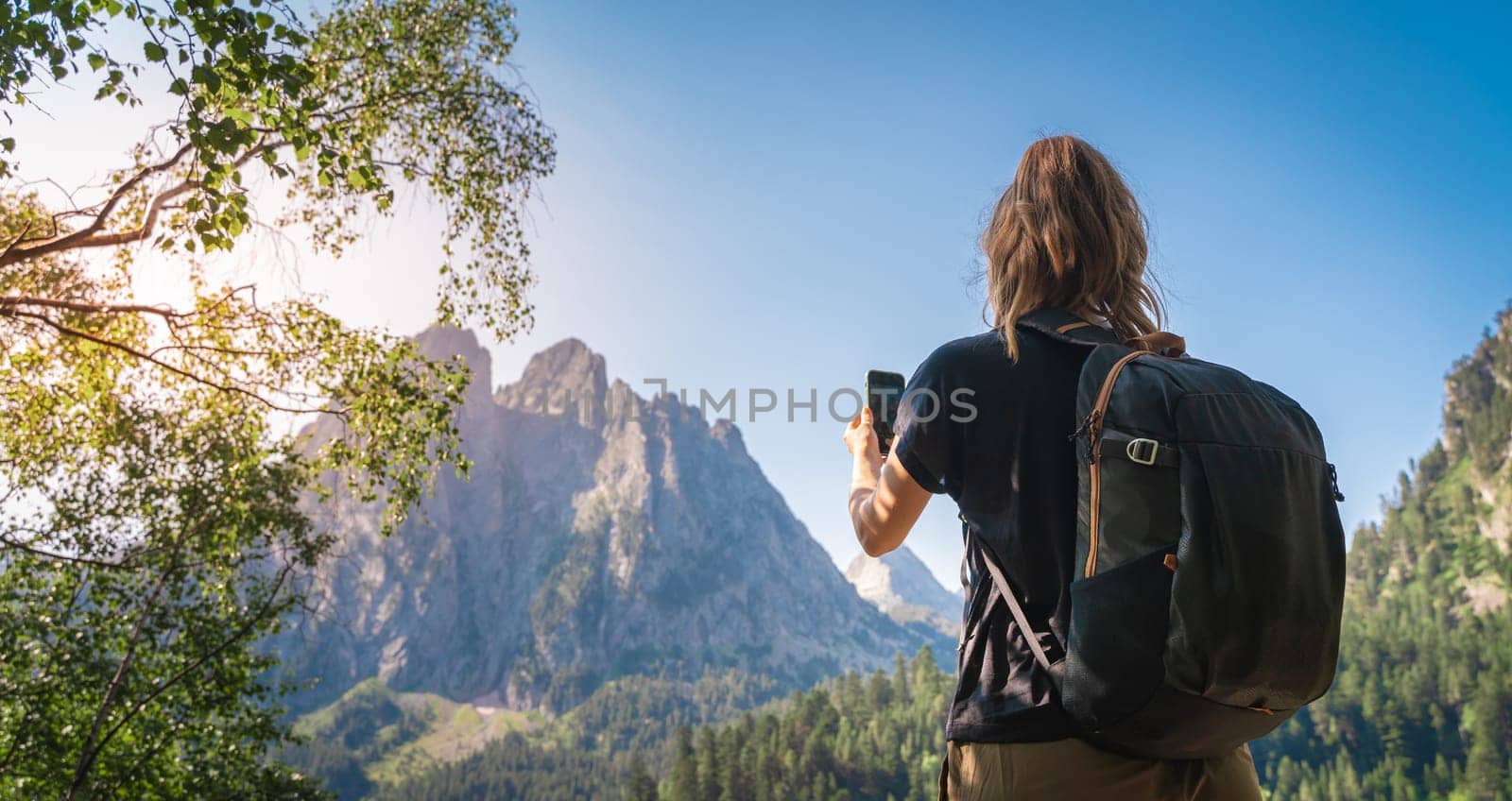 Young Attractive Woman taking a photo With her cellphone hiking in a Beautiful mountain in summer. Discovery Travel Destination Concept High quality photo