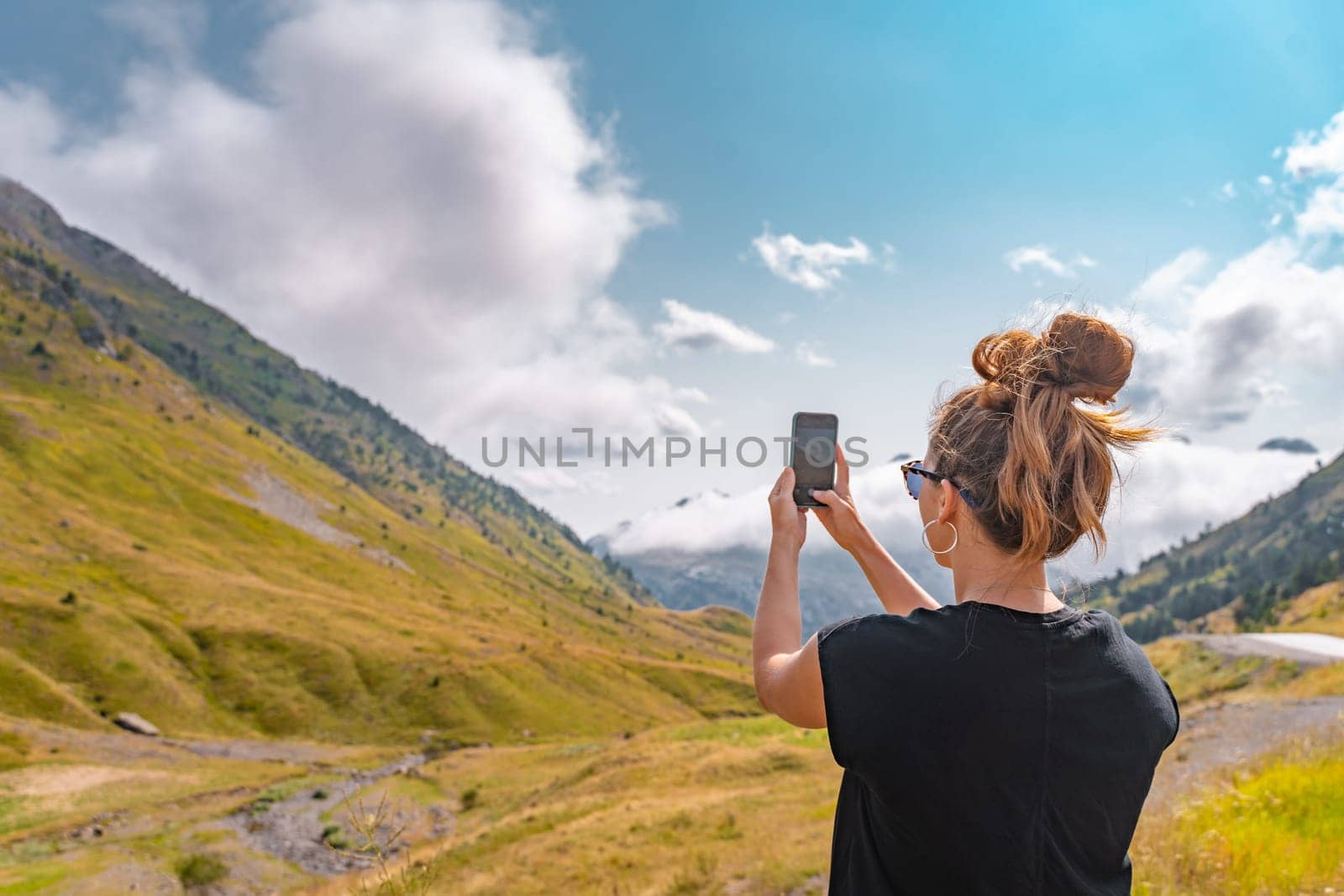 Young hiker Woman taking a picture with her cellphone in the top of a mountain. Discovery Travel Destination Concept. by PaulCarr