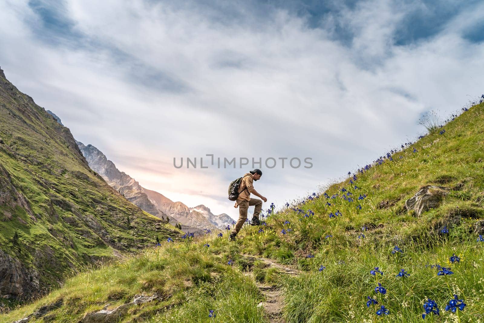 Happy male hiker trekking climbing a mountain. Effort and achievement concept. by PaulCarr