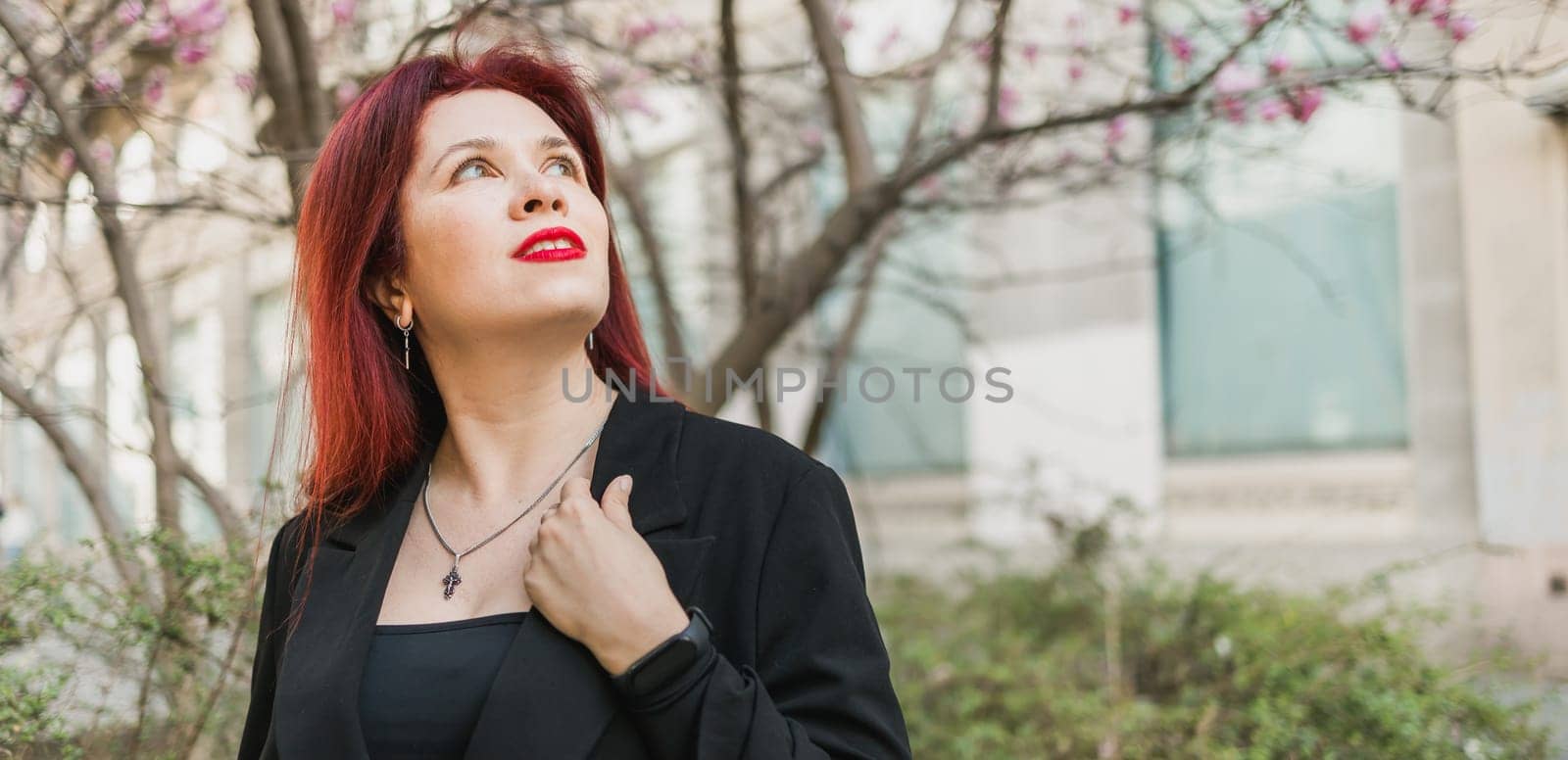 Banner Woman with magnolia flowers surrounded by blossoming trees copy space. Beauty and seasonal change and spring bloom season concept. by Satura86