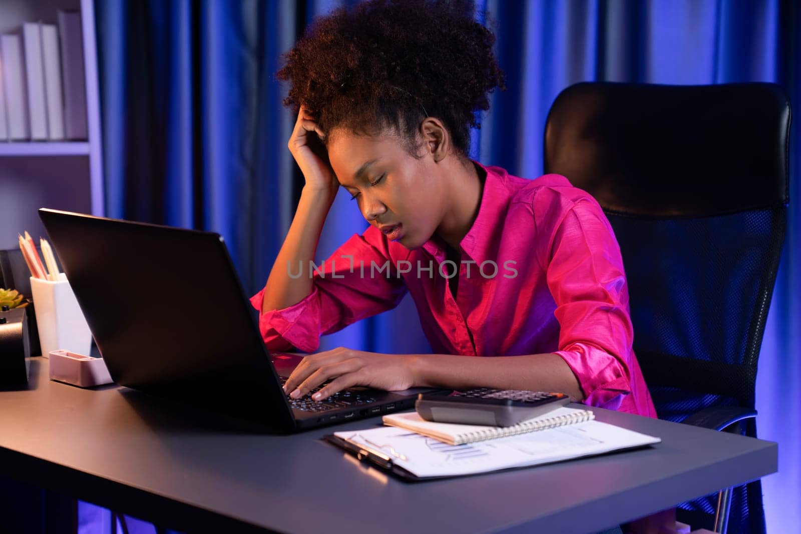 African woman freelancer feeling tried and take a nap on desk around by laptop and stationary, waiting for proceed project job until sleeping on desk. Concept of work life at home place. Tastemaker.