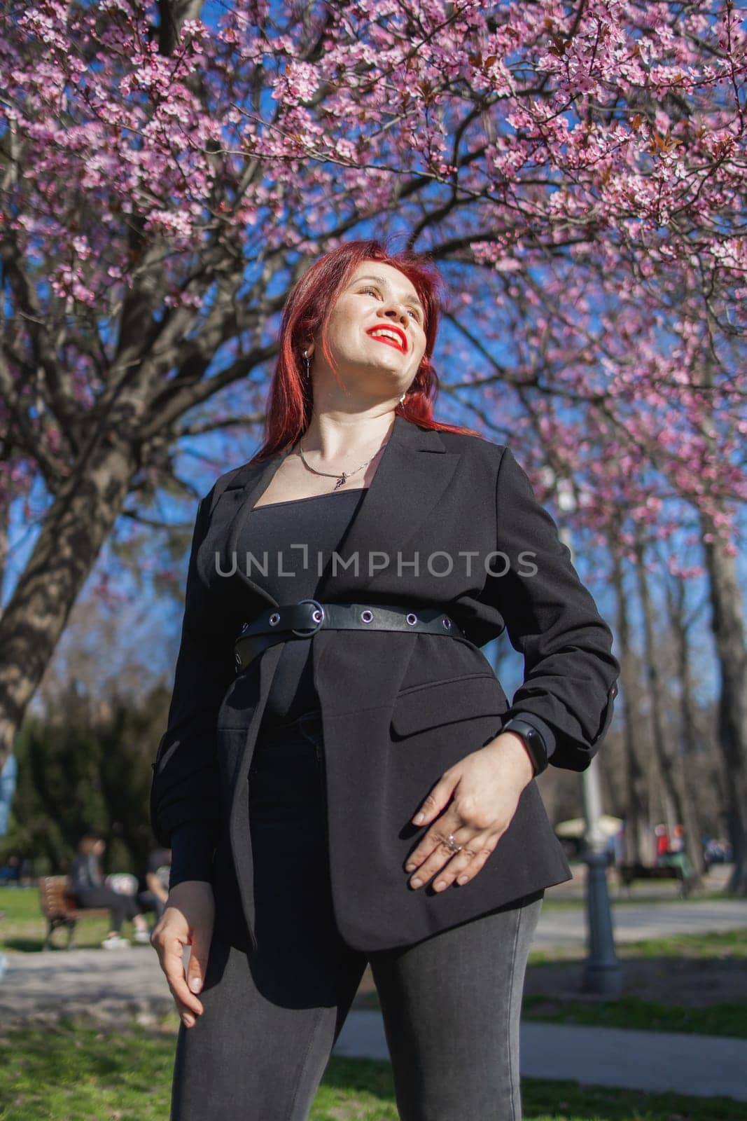 Woman with cherry flowers surrounded by blossoming trees copy space. Beauty and seasonal change and spring bloom season concept