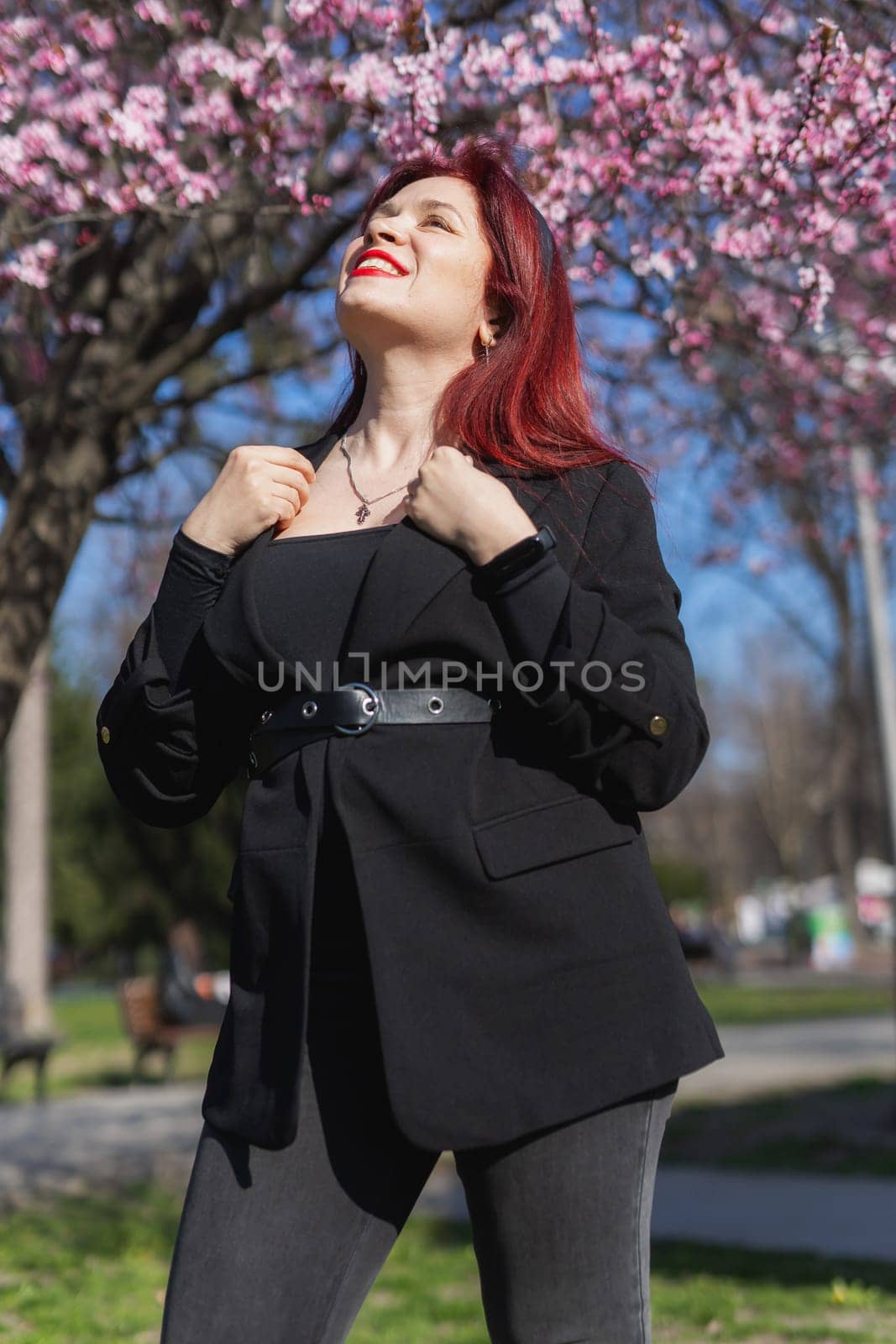 Woman with cherry flowers surrounded by blossoming trees copy space. Beauty and seasonal change and spring bloom season concept. by Satura86