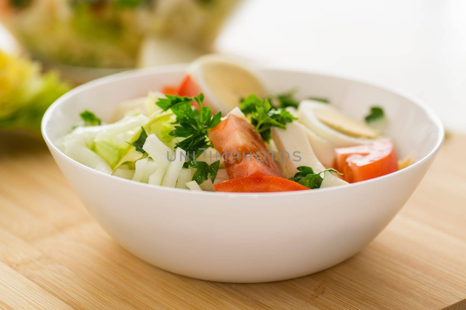 fresh vegetable salad, cabbage, tomatoes in a bowl on a wooden table .