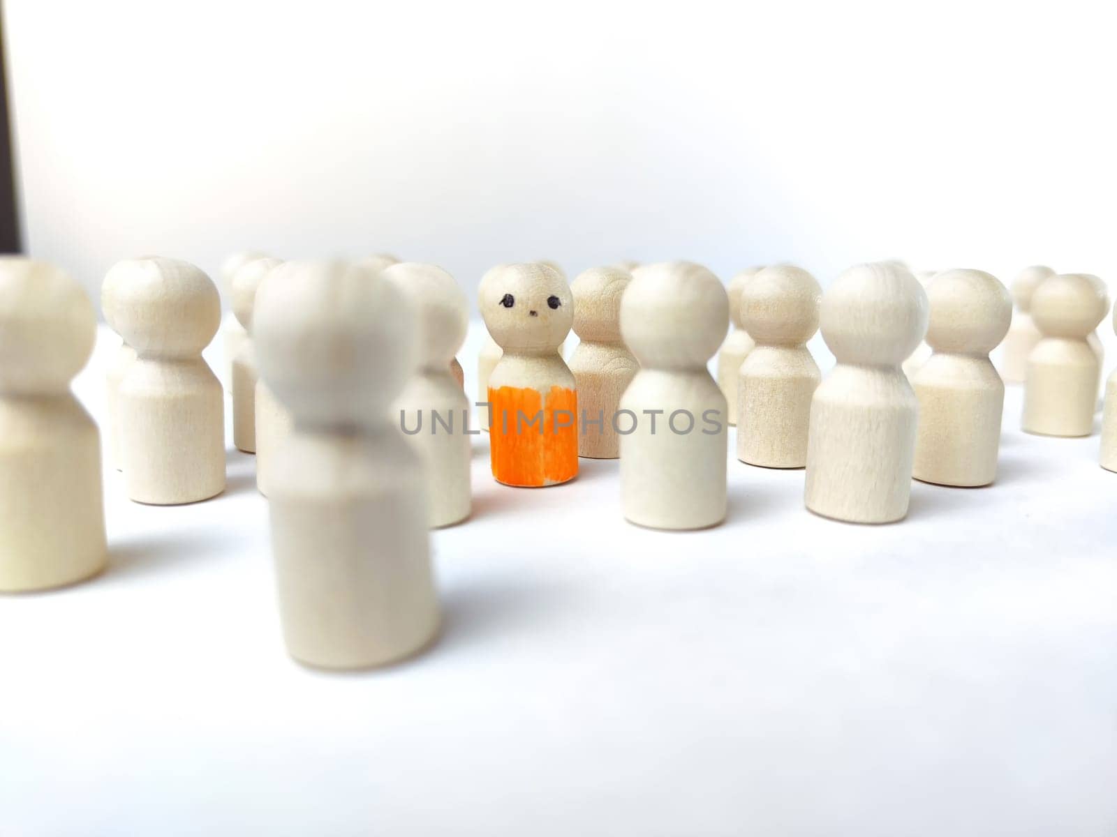 Wooden figurines with a leader and a group with partial focus. The concept of distinguishing a leader from the crowd. Sighted, intelligent, different among the blind group by keleny