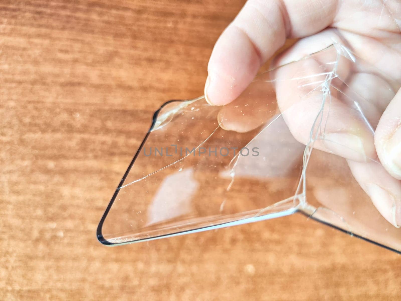 Removing Protective Film From Cracked Screen. Peeling off a cracked screen protector from a phone