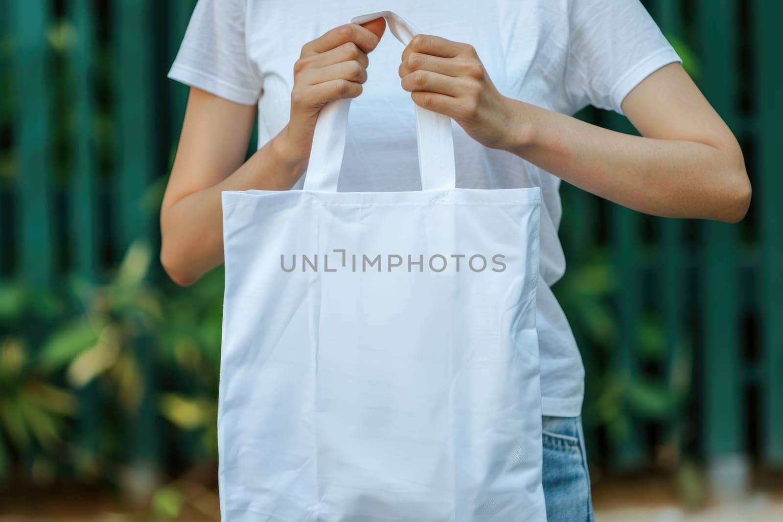 Woman is holding tote bag canvas fabric for mockup blank template, Empty reusable tote bag mockup.