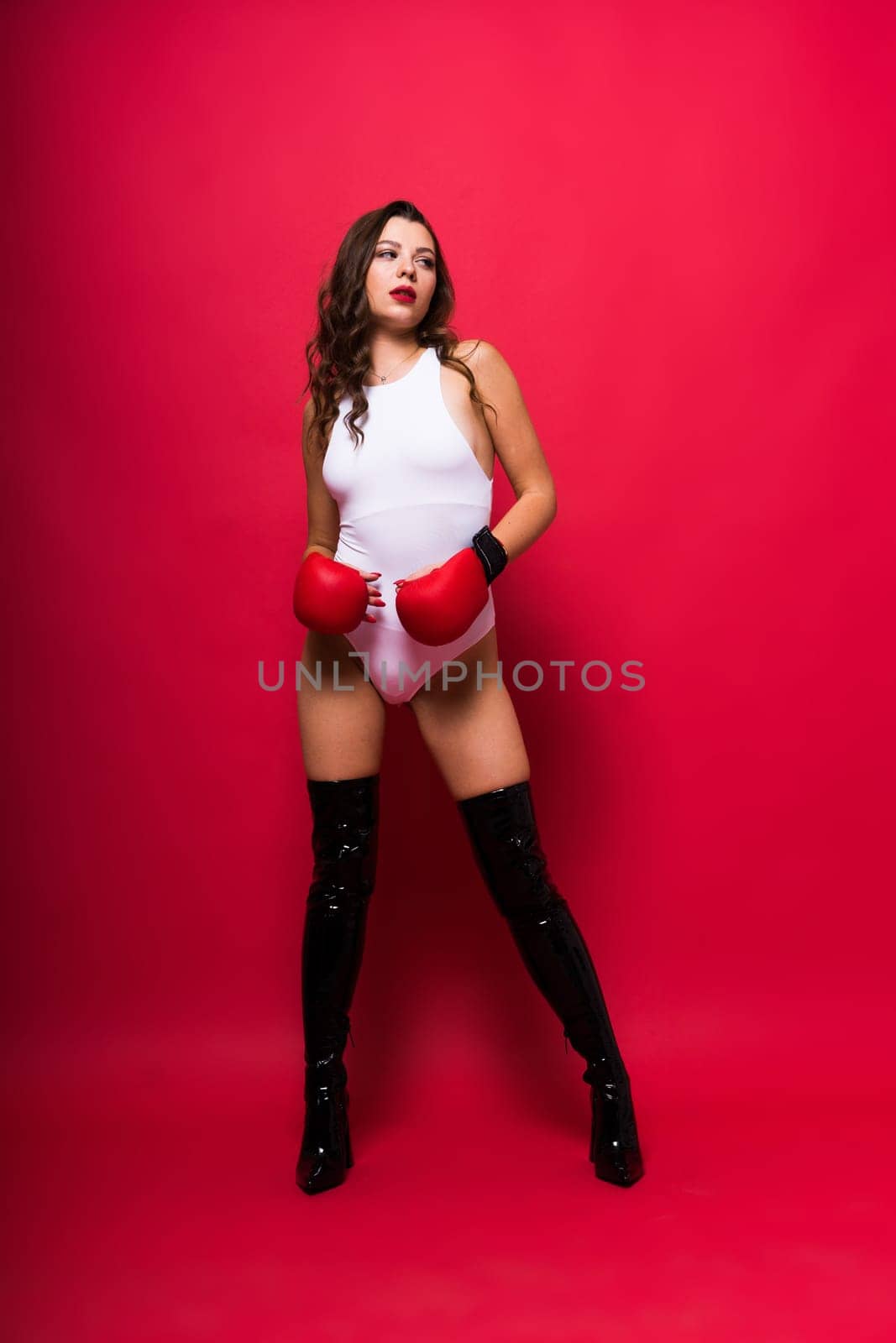 Studio portrait of a female seductive boxer in bodysuit and gloves by Zelenin
