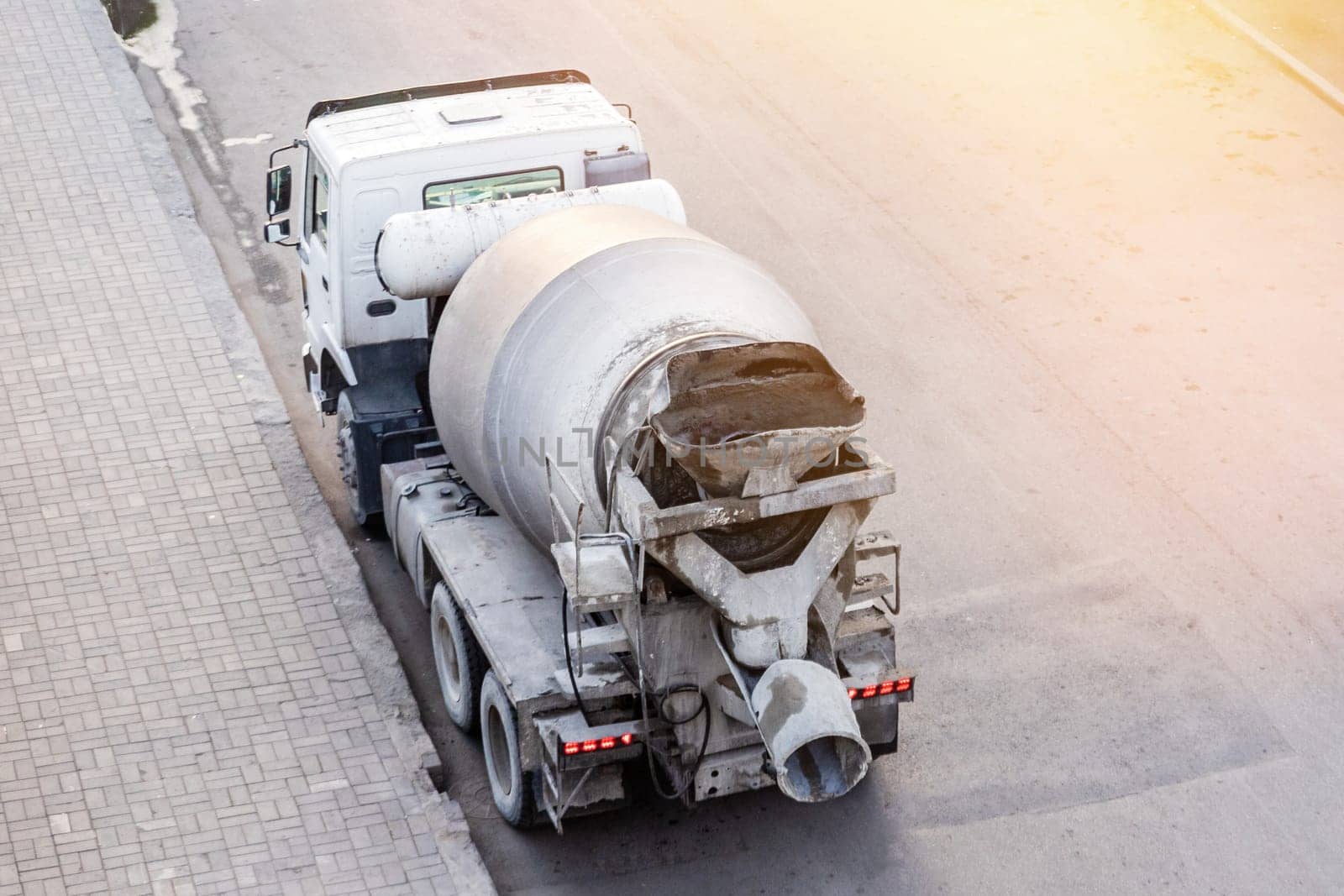 A concrete mixer truck stands on the road waiting in line to unload concrete, From Above view.