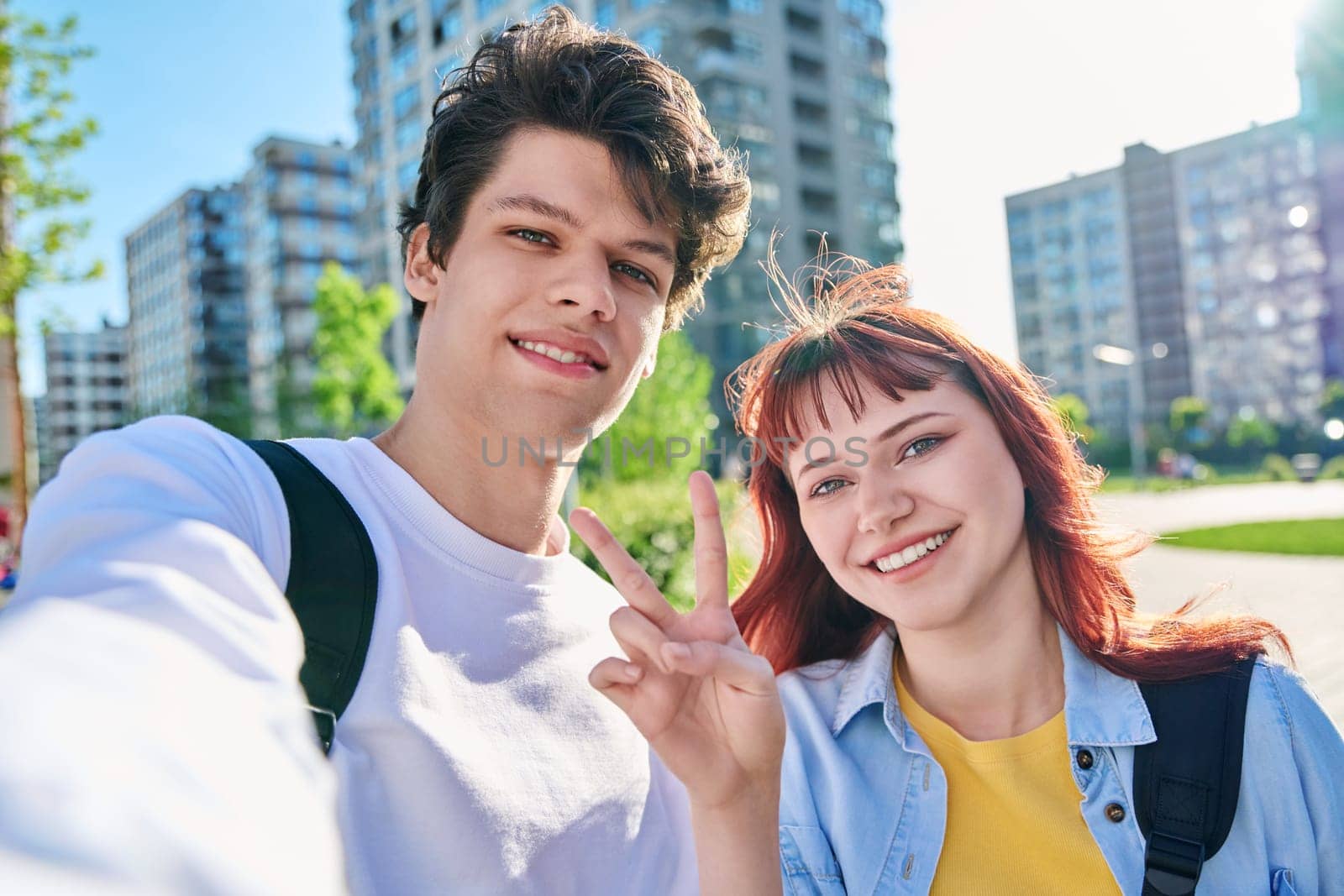 Selfie portrait of happy smiling joyful friends teenage couple guy and girl college students looking at camera, outdoor. Youth 19-20 years old, education, lifestyle, success, friendship concept