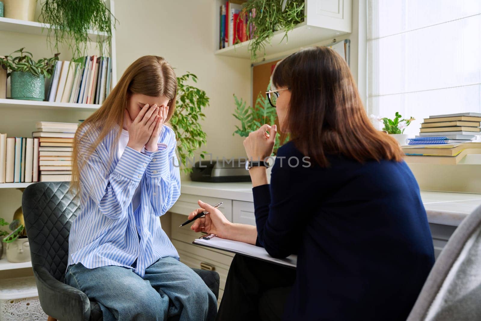 Sad upset young teenage female patient talking to professional mental therapist by VH-studio