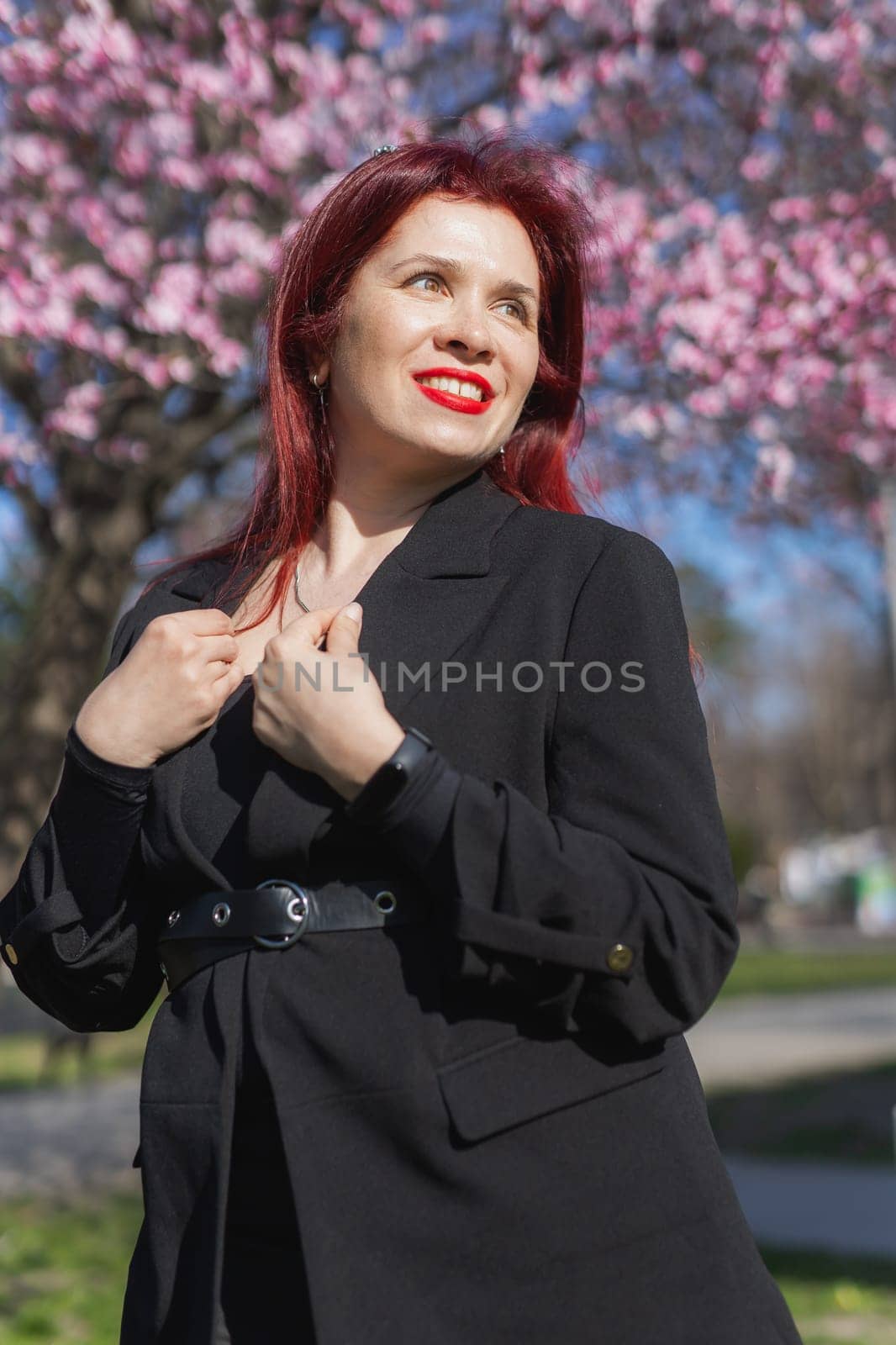 Woman with cherry flowers surrounded by blossoming trees copy space. Beauty and seasonal change and spring bloom season concept. by Satura86