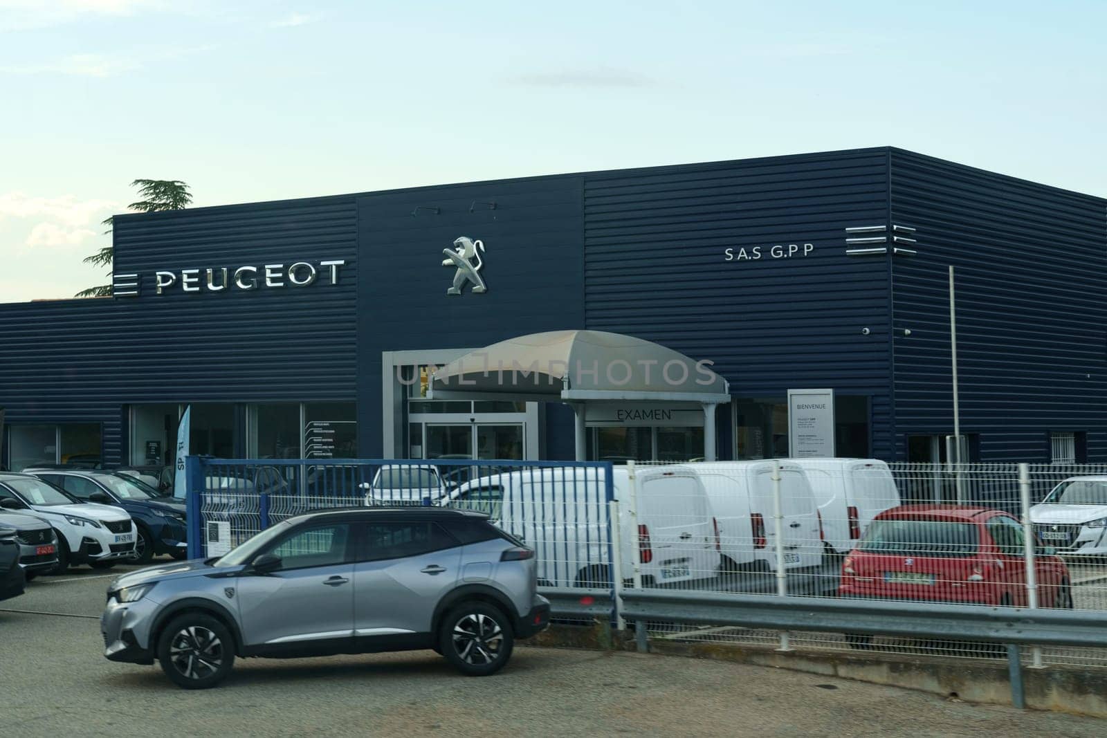 Peugeot Dealership Exterior Displaying New and Used Vehicles at Dusk by Sd28DimoN_1976