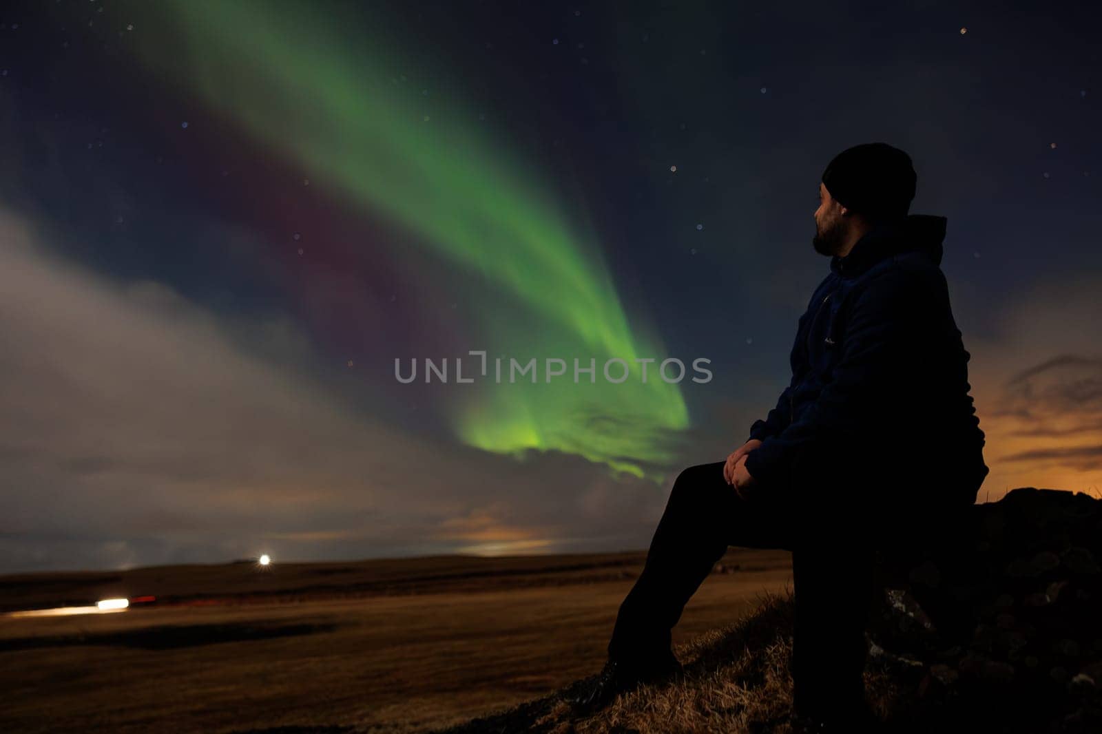 Traveller appreciating northern lights by DCStudio
