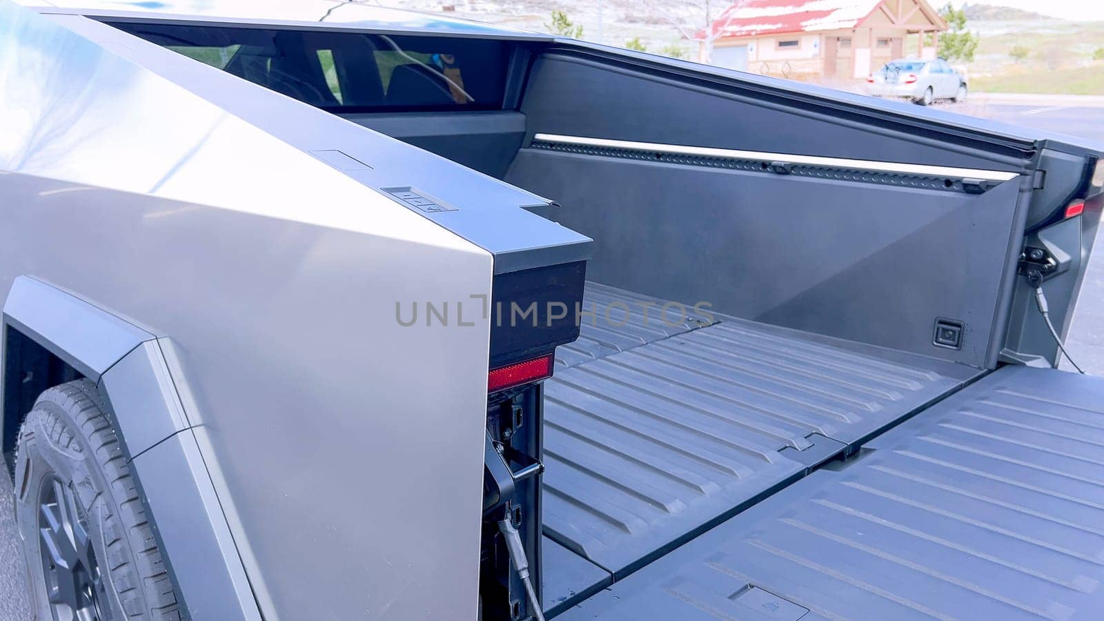 Open Cargo Bed of the Tesla Cybertruck in a Suburban Parking Lot by arinahabich