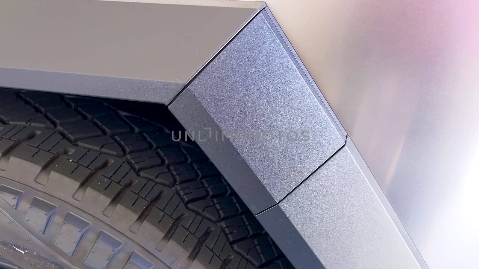 A close-up image emphasizing the sharp, angular design and textured metallic surface of the Tesla Cybertruck, showcasing the attention to detail in its robust and innovative construction.
