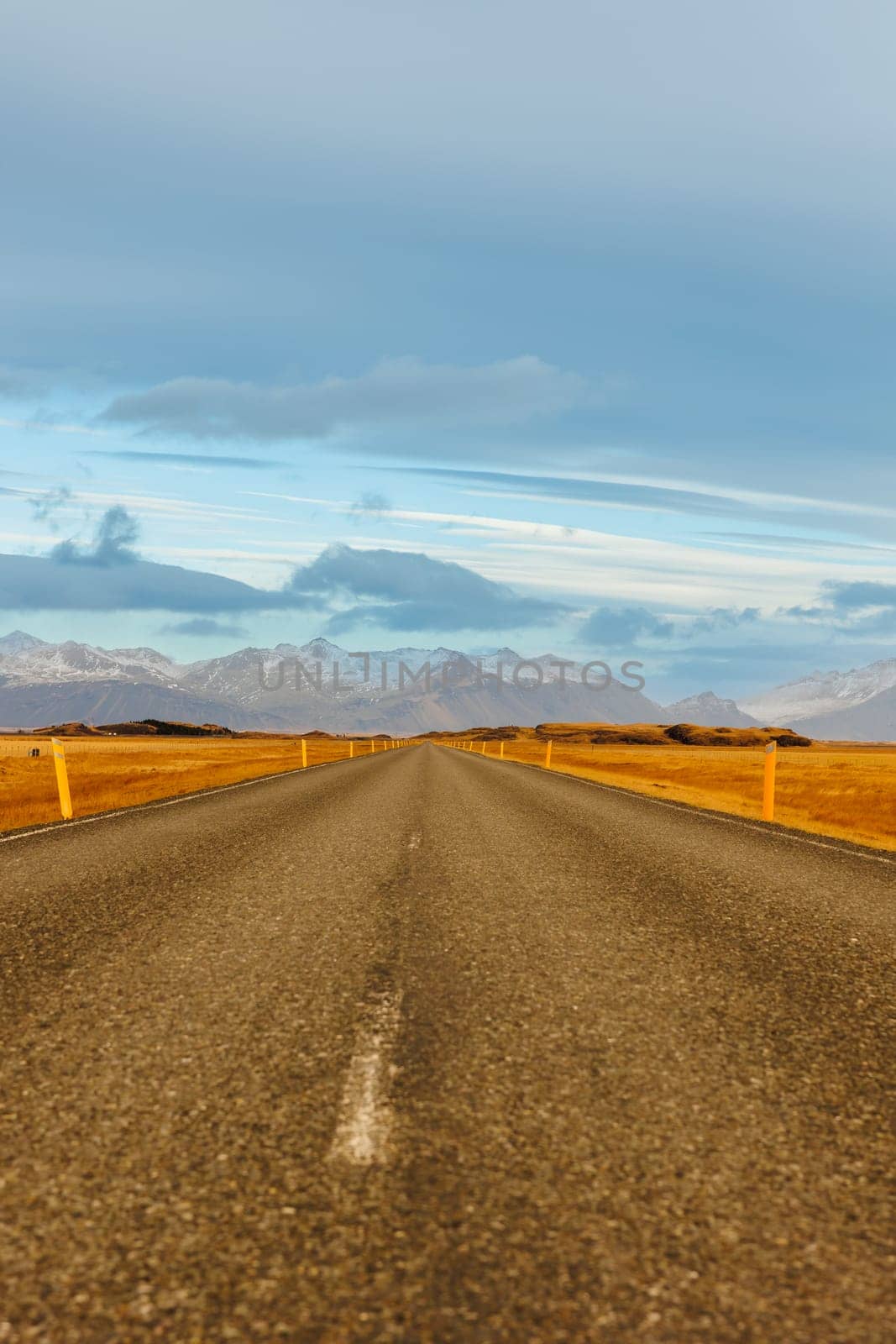 Lonely road in icelandic landscape with snow covered mountains and frosty fields, countryside highway. Spectacular long road in iceland with scandinavian hills and nordic nature.
