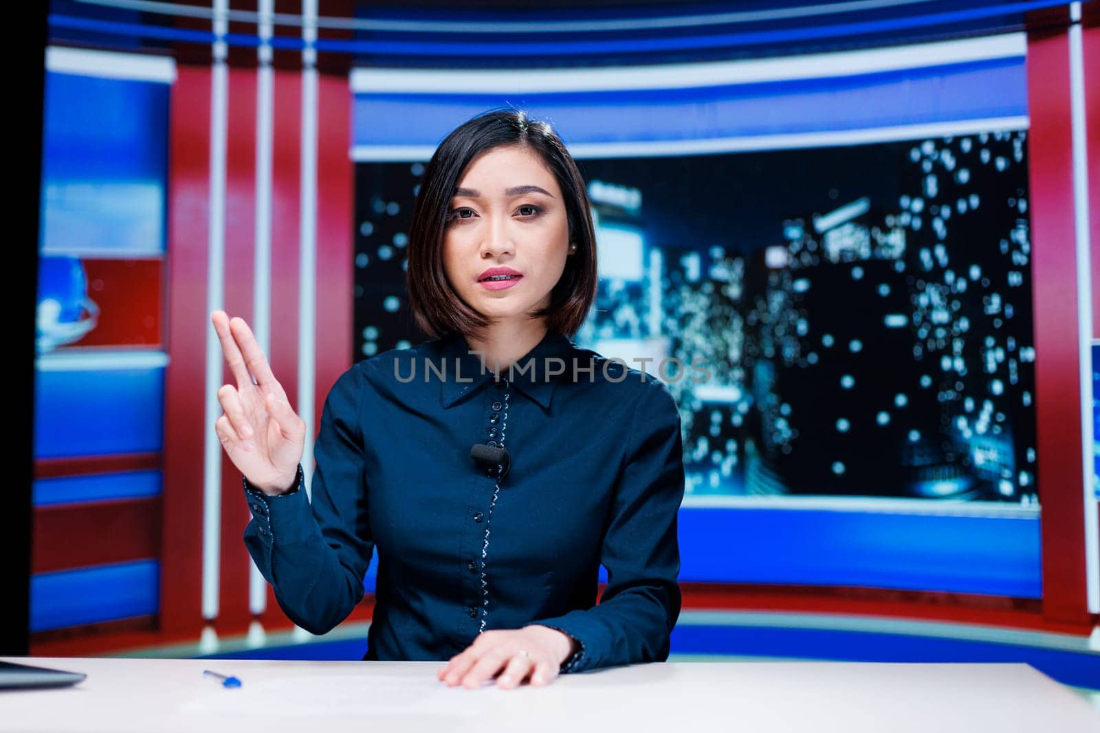 Presenter covering all breaking news topics and latest events occuring internationally, talking about issues in daily newscast reportage. Newscaster addressing celebrity drama in studio.
