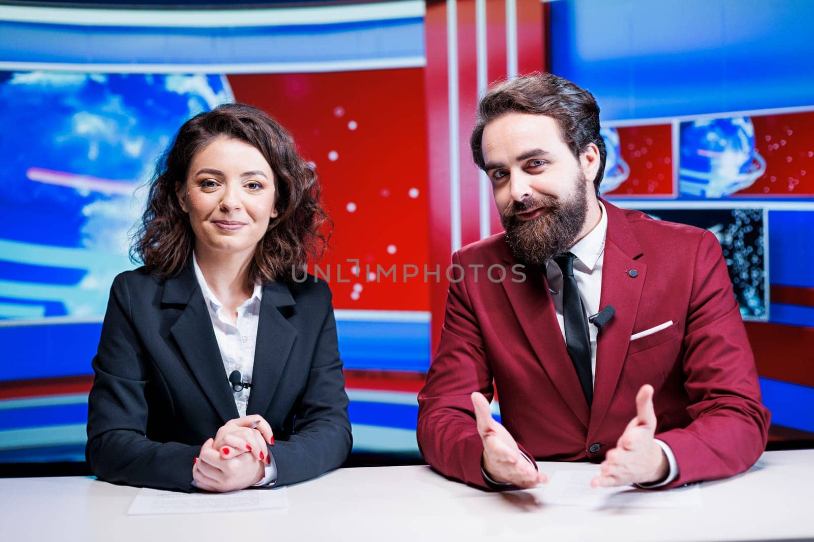Media reporters going live on tv to present latest news and international events, transmitting broadcast on global television program. Team of presenters reading daily headlines in newsroom.