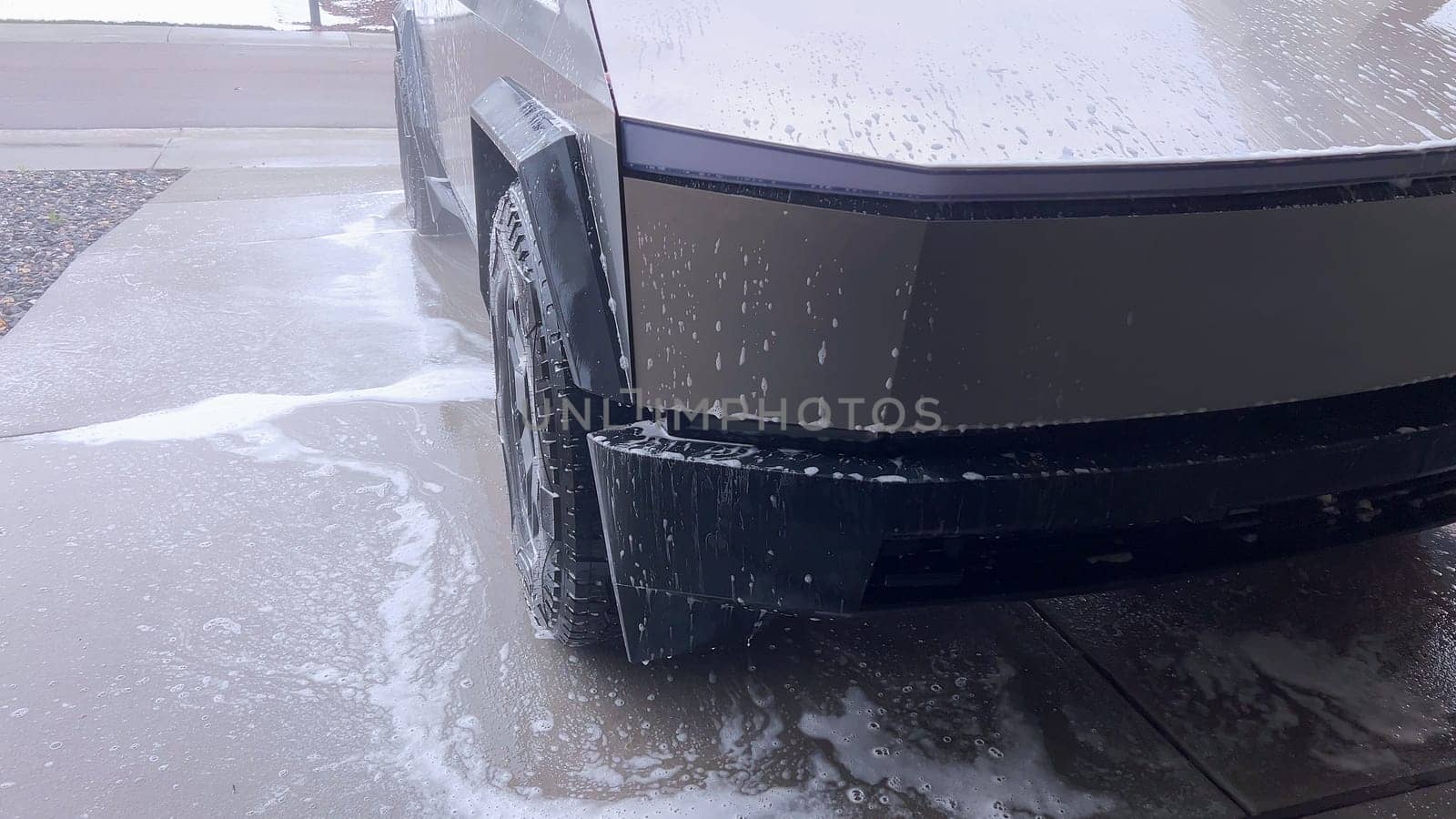 Denver, Colorado, USA-April 28, 2024- The front end of a Tesla Cybertruck is being meticulously cleaned using a high-pressure washer, showcasing the effectiveness of detailed vehicle maintenance and care.