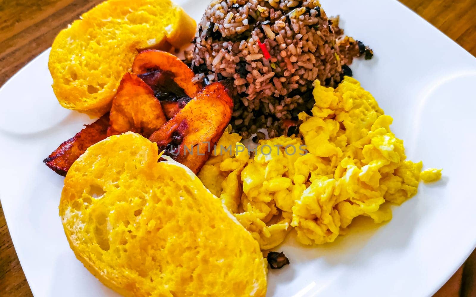 Typical Costa Rican food dish Rice Banana Scrambled eggs Beans and bread in Alajuela Costa Rica in Central America.