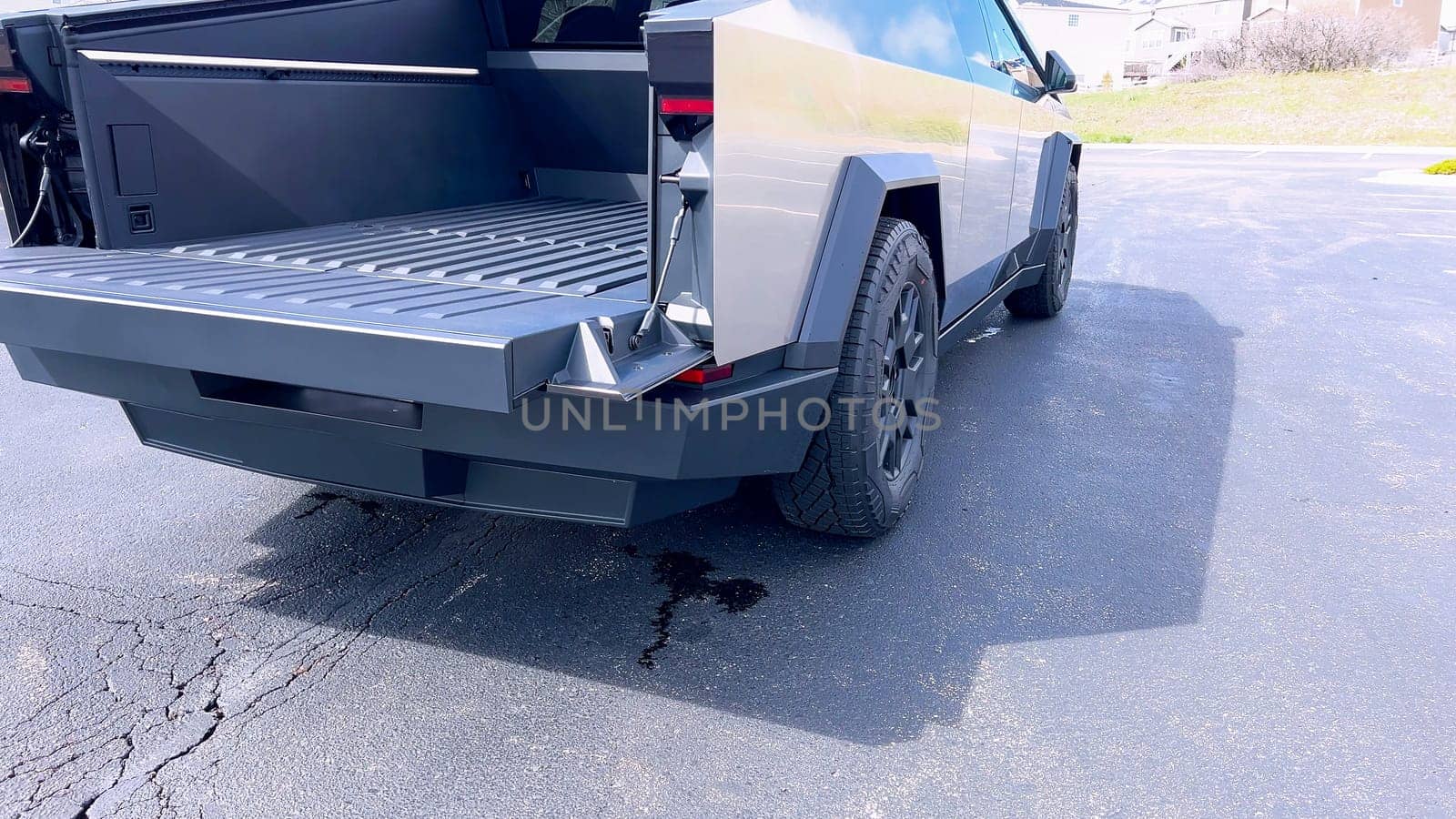 Denver, Colorado, USA-April 28, 2024- Showcasing the utility of the Tesla Cybertruck, this image features the vehicle open cargo bed, highlighting its spacious and functional design, parked in a suburban area with homes in the background.