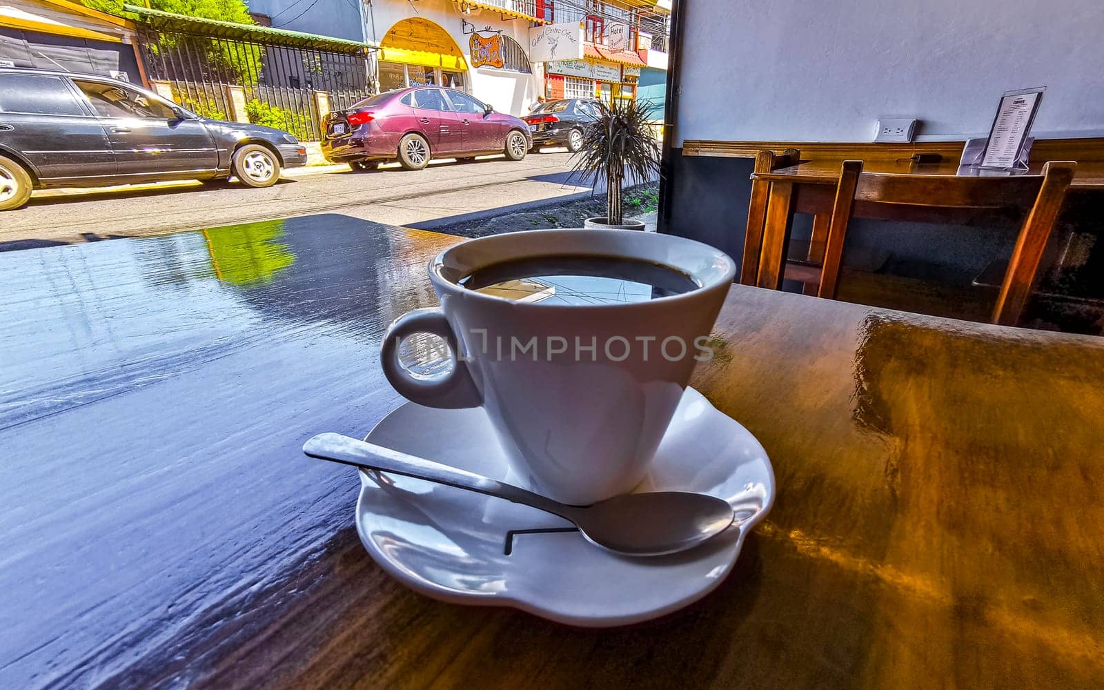 White cup of black Americano coffee on a wooden table in Alajuela Costa Rica in Central America.